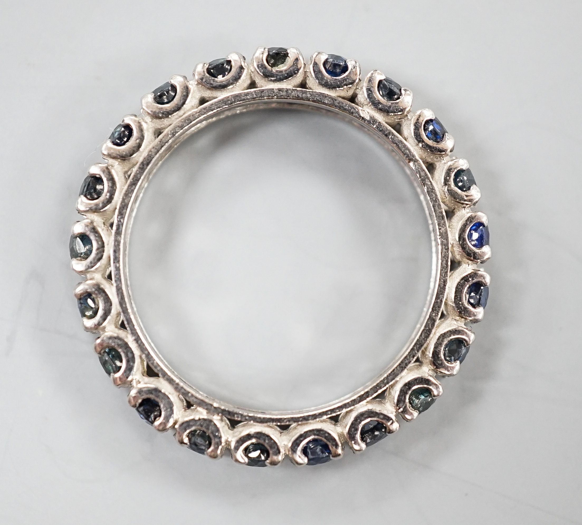 A white metal and sapphire set full eternity ring, size L, gross weight 3.4 grams.